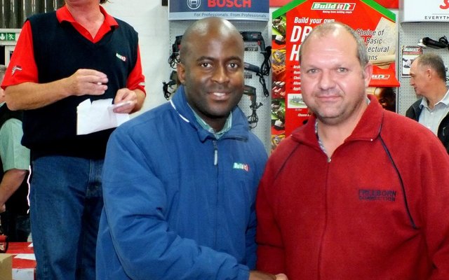 Brain Dube oorhandig â€˜n prys aan een van die vele pryswenners, Heinrich van Rensburg